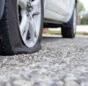 Close up of flat rear tire of white SUV track car vehicle automo